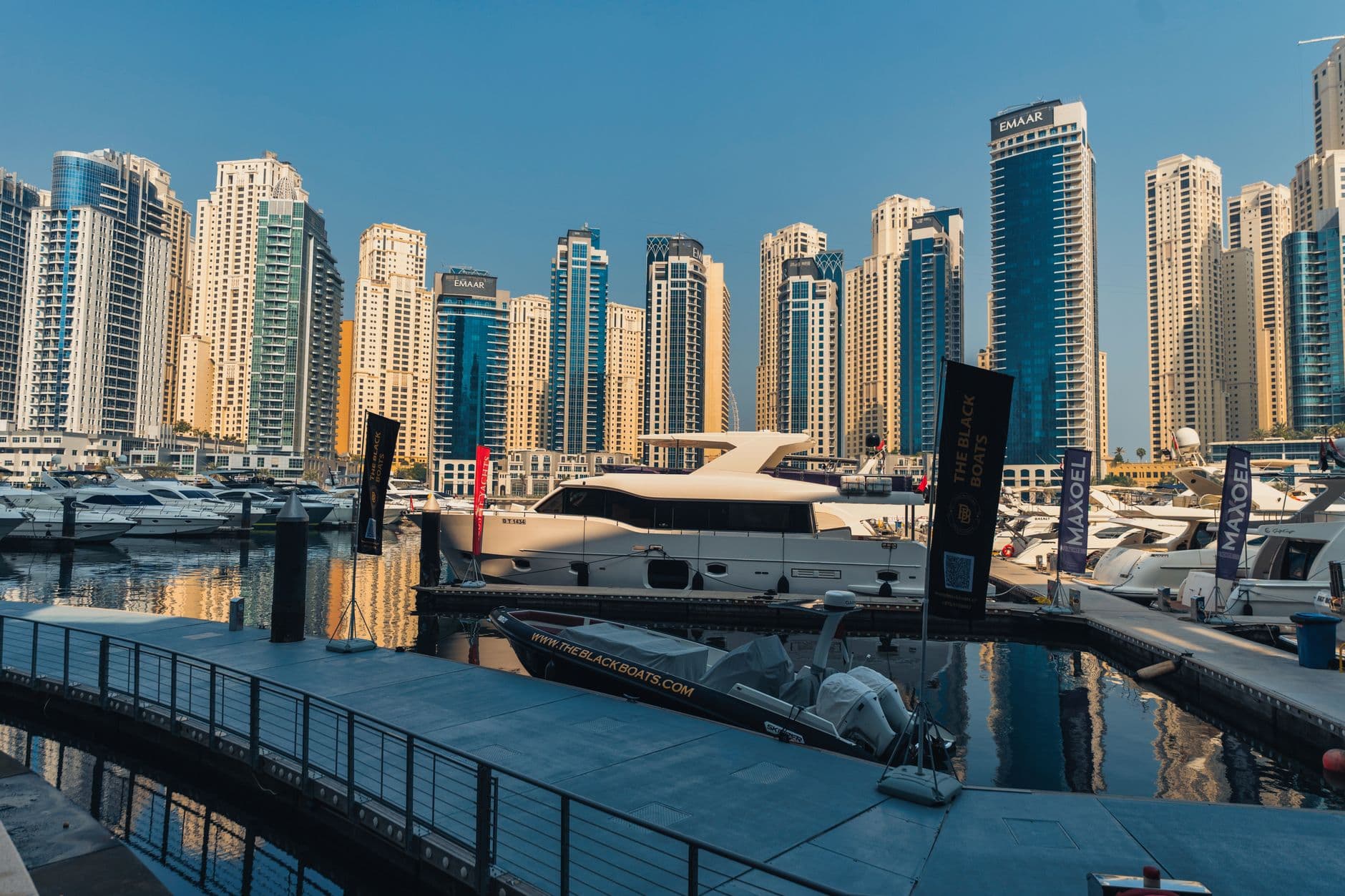 Luxury yachts anchored in Dubai Marina with towering skyscrapers. Perfect for travel and urban exploration.