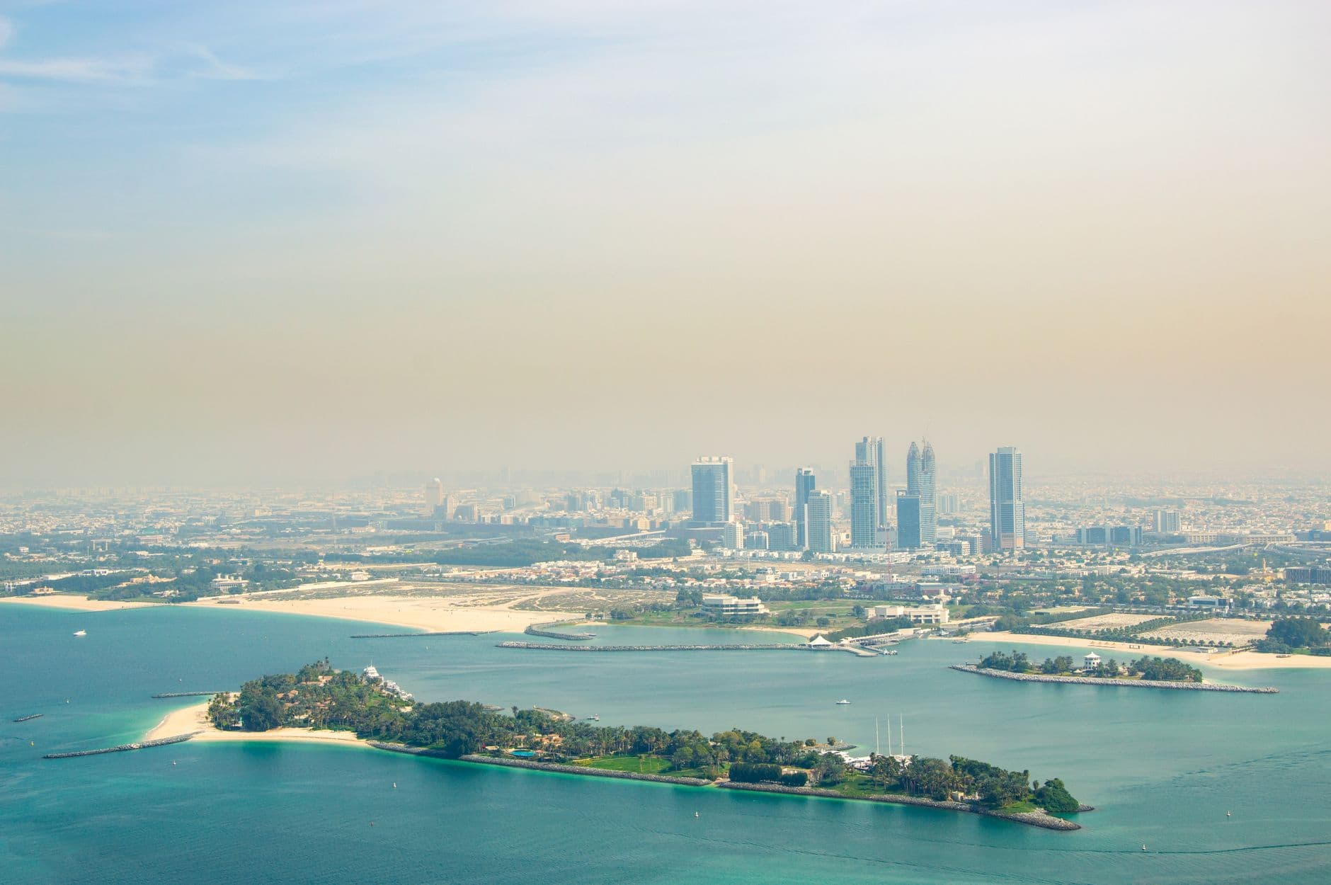 Stunning aerial view of Dubai's skyline with artificial islands and turquoise waters.