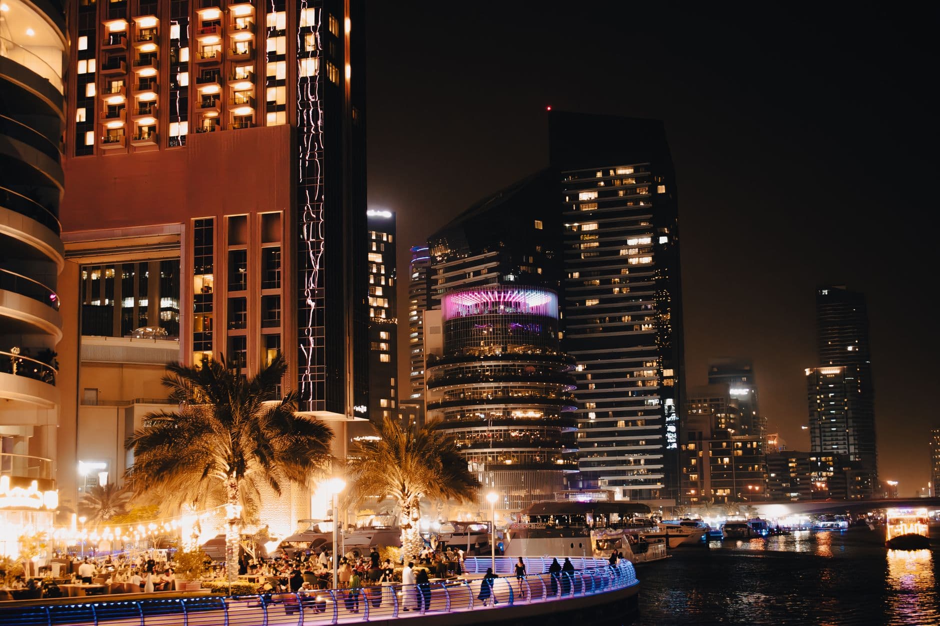 Explore the lively nightlife and illuminated skyline along Dubai Creek with modern architecture and city lights.